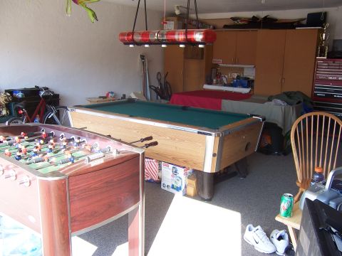 1993 Ford C-350 (Centurion Conversions) - A cluttered garage scene features a pool table and foosball table, along with various storage solutions and recreational items.