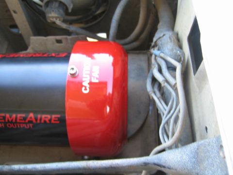 1990 Ford Bronco - red CAUTION FAN cap of an ExtremeAire compressor mounted in an engine bay beside a bundle of hoses.