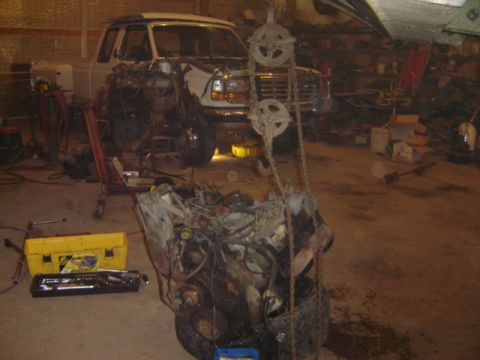 1992 Ford Bronco - A white Ford F-Series truck is in a garage with its engine being worked on.