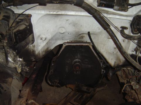 1992 Ford Bronco - Close-up view of a vehicle's engine transmission bell housing, showing hoses and wiring.