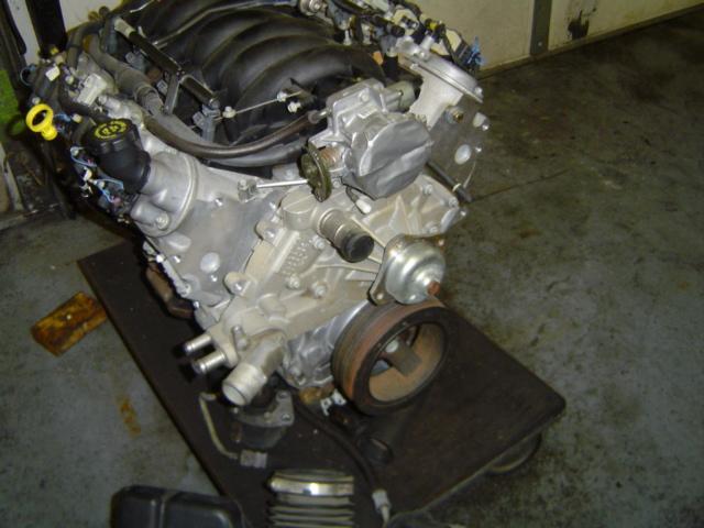 Engine on a stand, showing intake manifold, pulleys, and engine block