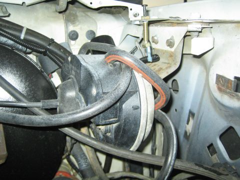 1990 Ford Bronco - Black plastic ductwork and rubber hoses route behind a white painted radiator support in an engine bay.