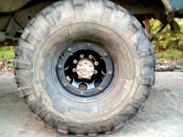 Off-road mud tire mounted on a black beadlock-style wheel on a lifted truck