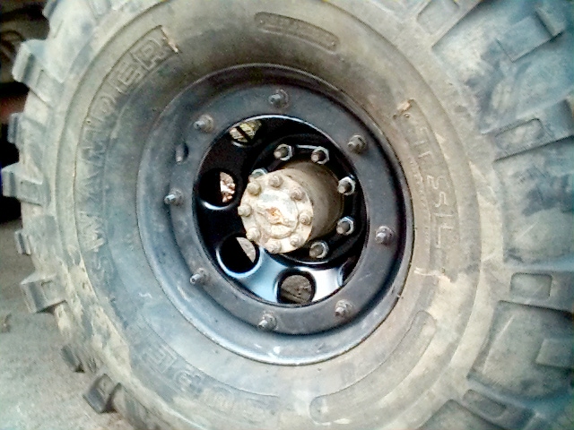 Black beadlock wheel with Swamper mud tire, exposed eight-lug hub and bolt ring