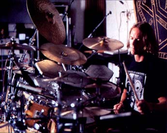 1991 Ford Bronco - A musician plays a drum set in a recording studio, surrounded by cymbals and equipment.