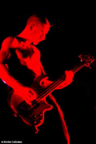 1991 Ford Bronco - A musician performs on stage, illuminated by red light, while playing a bass guitar.
