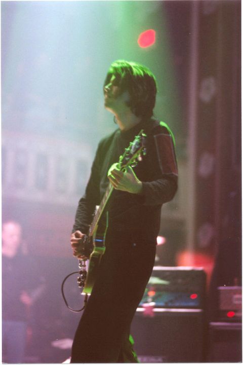 1991 Ford Bronco - A musician performs on stage, illuminated by colored lights while playing an electric guitar.