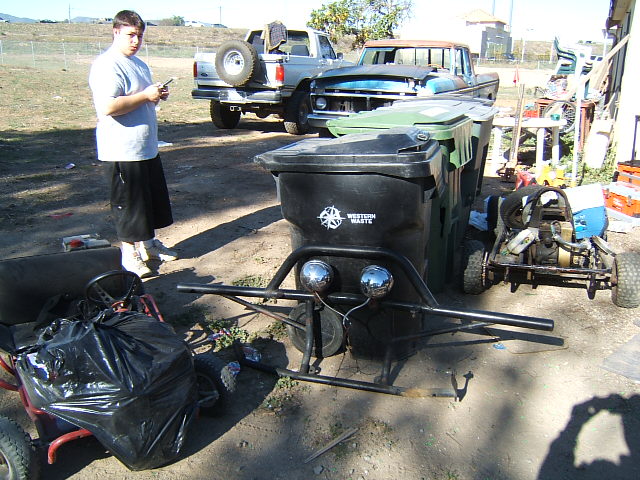Go-kart and two trucks parked outdoors