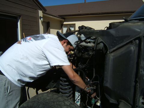 1988 Ford Bronco - Mechanic working on vehicle engine bay, focusing on wiring and suspension.