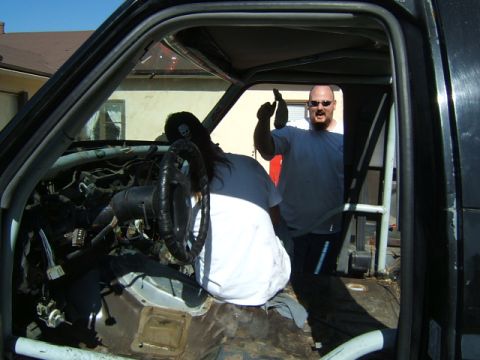 1988 Ford Bronco - The interior of a vehicle is shown with a roll cage and exposed wiring, indicating it is undergoing modification or repair.