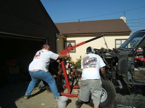 1988 Ford Bronco - Engine removal in progress with an engine hoist outside a garage.