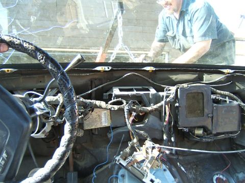 1988 Ford Bronco - Interior view of a car's dashboard with many wires exposed, undergoing repair or disassembly.