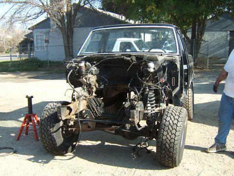 1988 Ford Bronco - The front end of a truck is disassembled, revealing the chassis and suspension components.