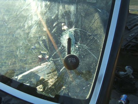 1988 Ford Bronco - The gear shifter is visible through a heavily cracked windshield, with markings indicating four-wheel drive options.