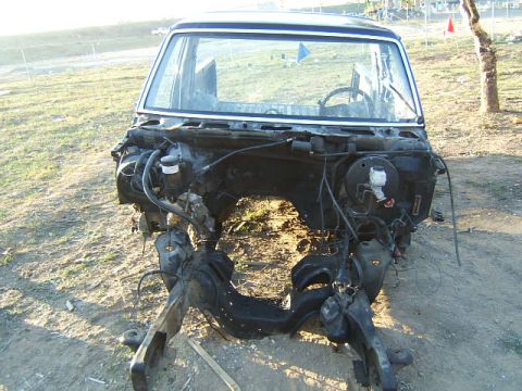 1988 Ford Bronco - The front clip of a disassembled vehicle is shown, revealing the engine bay and chassis structure.