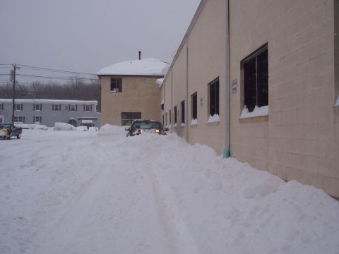 2001 Ford Crown Victoria - A car is stuck in a large snowdrift, with another vehicle visible in the background.