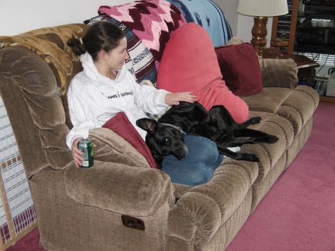 1995 Ford Bronco - A woman relaxes on a recliner couch with her dog, holding a beverage.