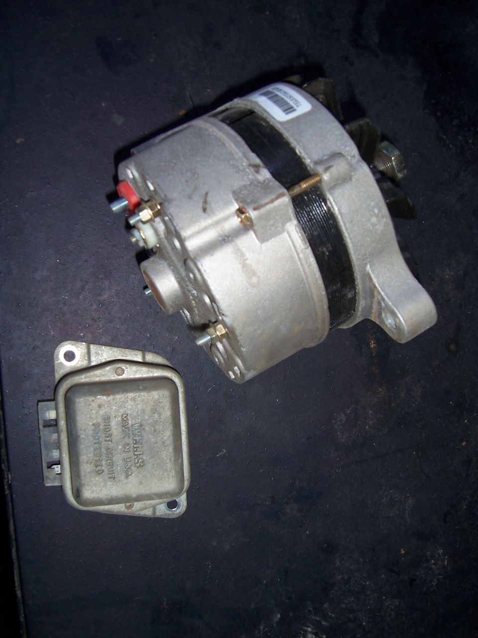 Alternator and voltage regulator on dark surface