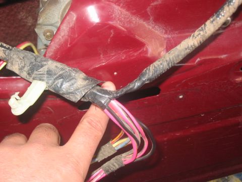 1991 Ford Bronco - A close-up view of a red interior panel reveals a taped wiring harness with multiple colored wires.
