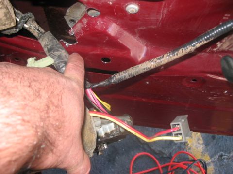 1991 Ford Bronco - Close-up view of the interior door wiring harness and electrical connectors on a red vehicle panel.