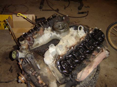 1992 Ford Bronco - Engine part shown in a workshop setting with tools and boxes in the background.
