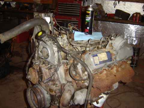 1992 Ford Bronco - Engine assembly with fuel lines and electrical connectors visible, resting on a workbench.