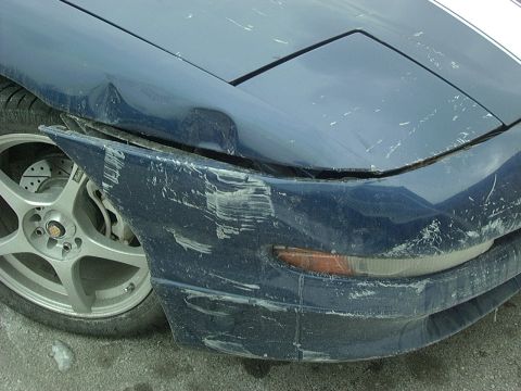 1995 Ford Probe - The front of a blue car shows significant damage to the bumper and fender.