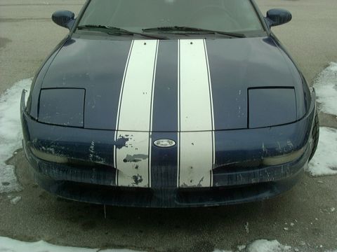 1995 Ford Probe - Front view of a blue 1995 Ford Probe with racing stripes. The car shows some damage to the front bumper.