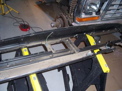 1978 Ford Bronco - A disassembled vehicle dashboard component is shown supported by sawhorses in a garage setting.