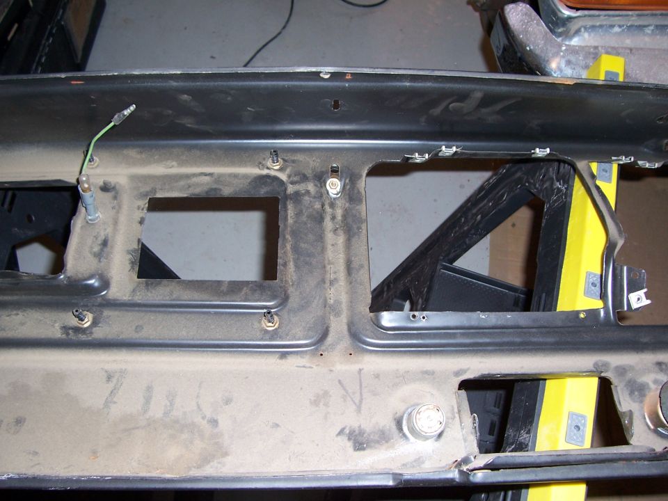 Close-up of a dusty vehicle dashboard frame with cutouts for instruments