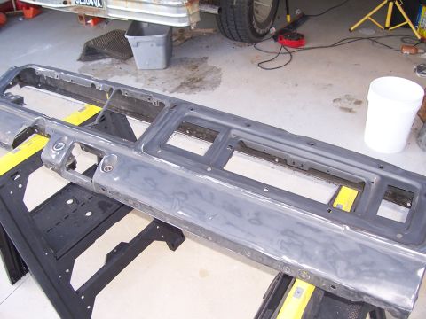 1978 Ford Bronco - A bare metal dashboard panel, stripped of pad, gauges and vents, resting on yellow sawhorses in a garage with its instrument cluster and ra…