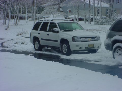 2005 Chevrolet TrailBlazer - A white 2005 Chevrolet TrailBlazer is parked in the snow, with another vehicle partially visible on the right.