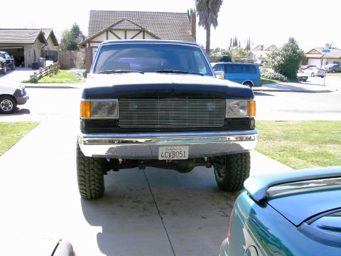 1988 Ford Bronco - This 1988 Ford Bronco features a prominent chrome grille and a lifted suspension, viewed from the front.