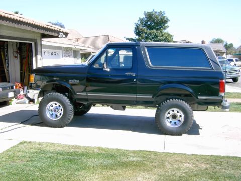 1988 Ford Bronco - This lifted 1988 Ford Bronco is parked in a driveway with a garage in the background.