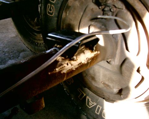 1985 Ford Bronco - A close-up view of a vehicle's rear axle, showing a brake line and part of a tire.