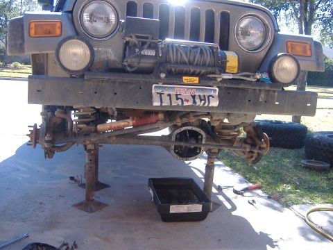 2004 Jeep Wrangler - Front end of a 2004 Jeep Wrangler lifted for suspension repair, a winch mounted on the bumper.