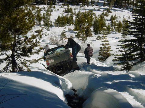 1986 Ford Bronco - People attempt to free a truck stuck in a snowy ravine during winter.
