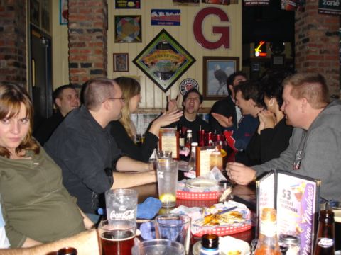 1985 Ford Crown Victoria LTD - A group of friends enjoys a night out at a bar, with drinks and snacks on the table.