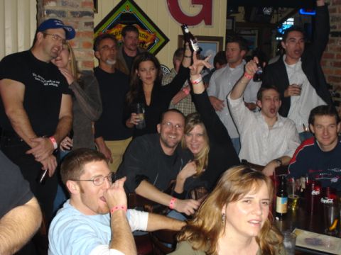 1985 Ford Crown Victoria LTD - A group of friends are gathered at a bar, some holding drinks and appearing to cheer.