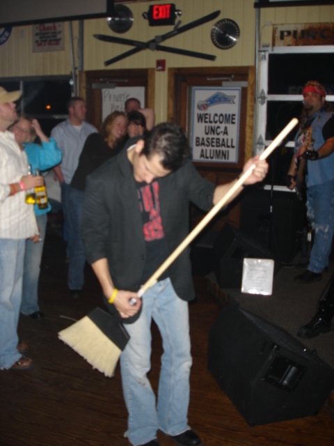 1985 Ford Crown Victoria LTD - A man sweeps the floor of a bar while a band plays in the background.