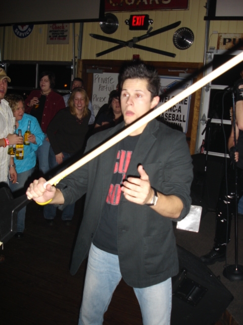 1985 Ford Crown Victoria LTD - Man holding a pool cue at a bar with other people visible in the background.
