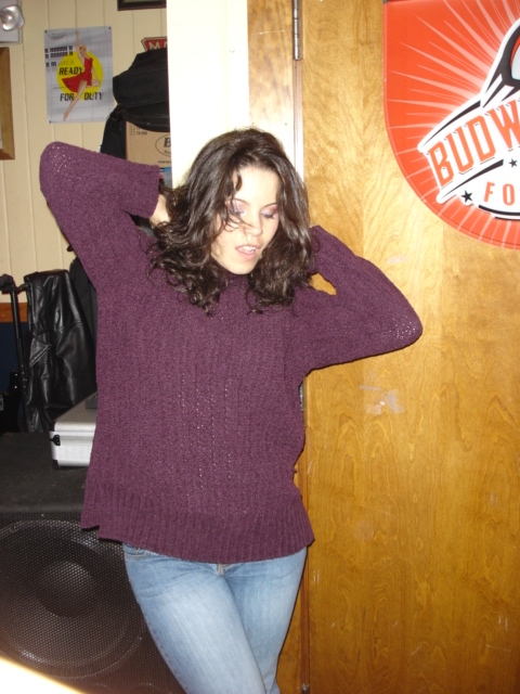 1985 Ford Crown Victoria LTD - Woman in a purple sweater and jeans poses indoors, with a Budweiser sign visible on the right.