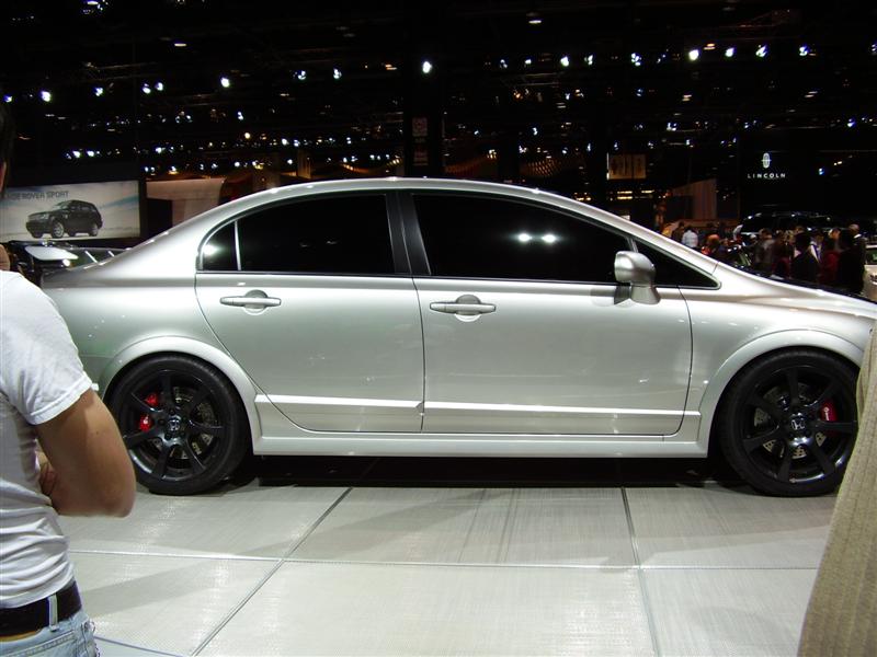 Silver sedan with black rims and red brake calipers on display