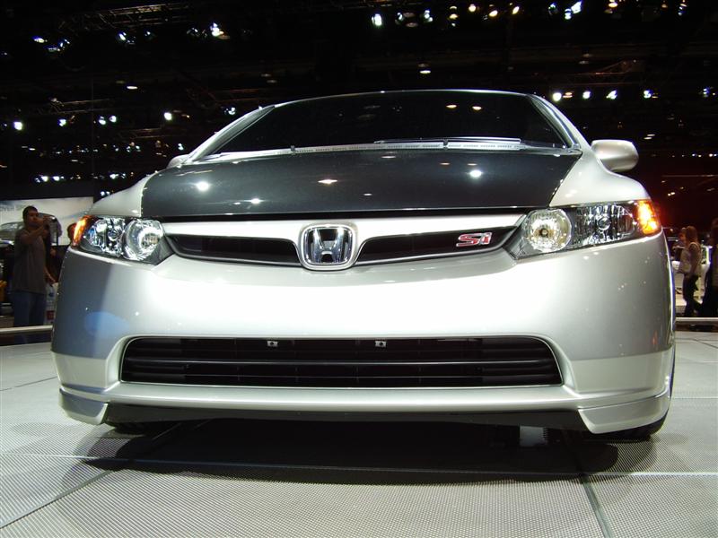 Silver Honda Civic Si front view with dark hood and red SI badge