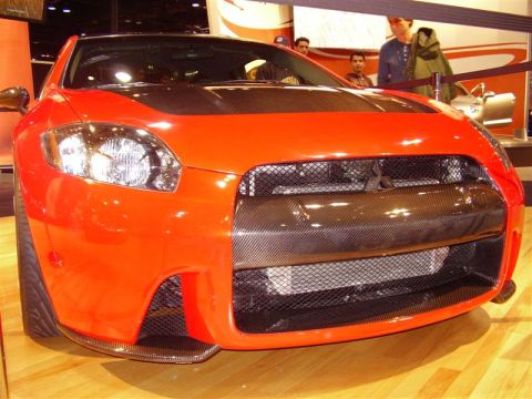 1997 Ford Taurus - This orange sports car has a distinctive carbon fiber grille and hood, seen at an auto show.