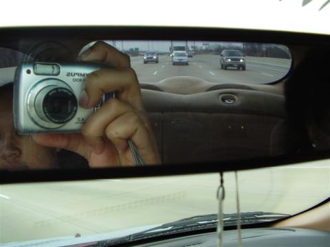 1997 Ford Taurus - A selfie taken in a car's rearview mirror shows multiple vehicles driving on a highway.
