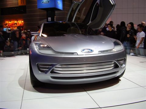 1997 Ford Taurus - A silver concept car with butterfly doors and a distinctive horizontal grille is displayed at an auto show.