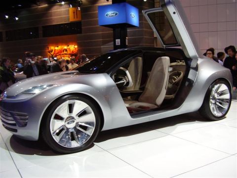 1997 Ford Taurus - Silver concept car with butterfly doors displayed at an auto show.