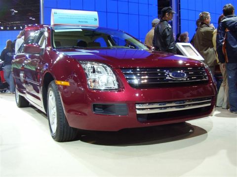 1997 Ford Taurus - This Ford sedan, likely a 2006 model, is displayed at an auto show with a blue backdrop.