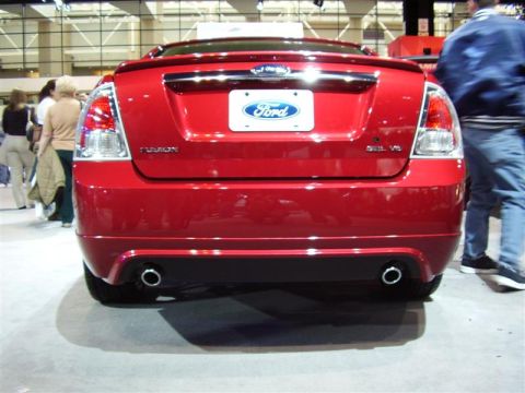 1997 Ford Taurus - This red Ford sedan features a prominent Ford badge and dual exhaust pipes, indicating it is not a 1997 model.